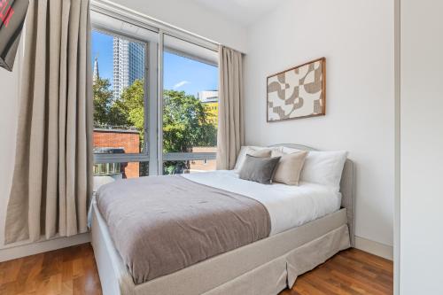 a bedroom with a bed and a large window at Luxury Penthouse - Soho - Central - Sleeps 6 in London