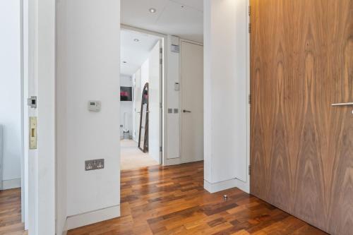 a hallway with white walls and a wooden door at Luxury Penthouse - Soho - Central - Sleeps 6 in London