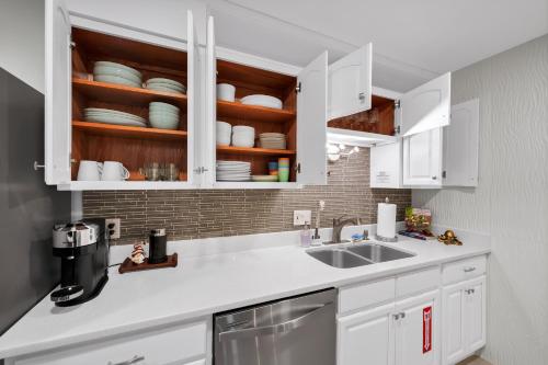 a kitchen with white cabinets and a sink at Lexy Beach House in Cape Canaveral
