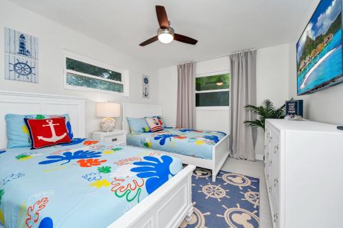 a bedroom with two beds and a ceiling fan at Lexy Beach House in Cape Canaveral