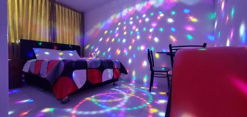 a bedroom with a bed and a wall with lights at Hospedaje El Paraiso in Santa Eulalia