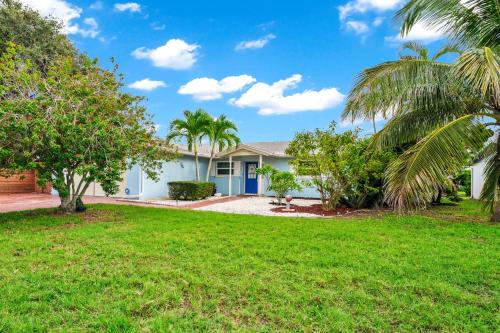 a house with palm trees in a yard at Lexy Beach House in Cape Canaveral