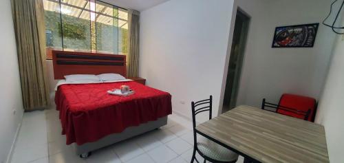 a bedroom with a bed and a table and a window at Hospedaje El Paraiso in Santa Eulalia