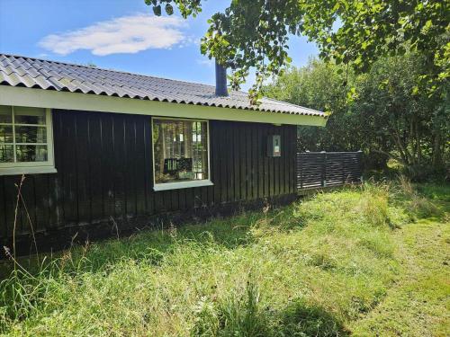 a black house with a fence in front of it at FAN026-Fano-Hedesvinget-12 in Fanø