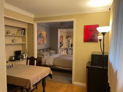 una habitación con un dormitorio con una cama y una mesa en Suit near Grousmountain, en North Vancouver