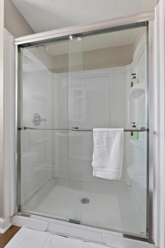 a shower with a glass door in a bathroom at Trendy Ohio City Parking Wifi Mins to DT in Cleveland