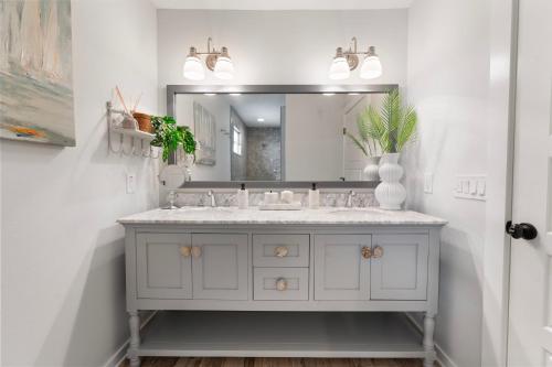 um banheiro com uma pia e um espelho em Luxury Oceanfront Vacation Home in Cocoa Beach 6 Bedrooms, Game Room & Direct Beach Access Sleeps 14 em Cocoa Beach