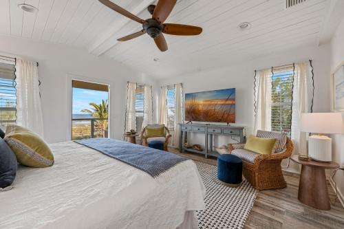 um quarto com uma cama e um ventilador de teto em Luxury Oceanfront Vacation Home in Cocoa Beach 6 Bedrooms, Game Room & Direct Beach Access Sleeps 14 em Cocoa Beach