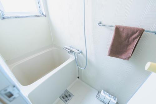 a bathroom with a tub and a shower with a towel at LEON RESORT HOTEL Max 9 people 3 min taxi Ikebukuro Station Tiffany Blue yellow Room 最大9名 池袋 in Tokyo