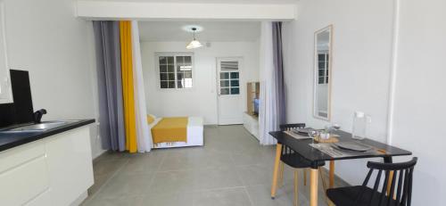 a kitchen with a table and a dining room at La Fleur Doré Studio in Le Vauclin