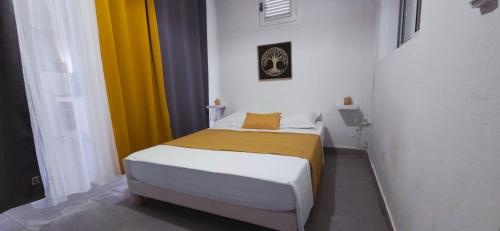 a small bed in a room with colorful curtains at La Fleur Doré Studio in Le Vauclin