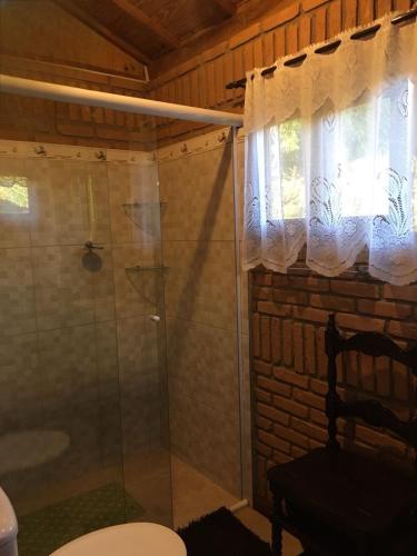 un bagno con doccia, WC e finestra di Recanto da Deusa a Bocaina de Minas