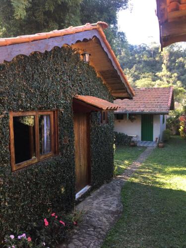 un edificio ricoperto di edera accanto a una casa di Recanto da Deusa a Bocaina de Minas