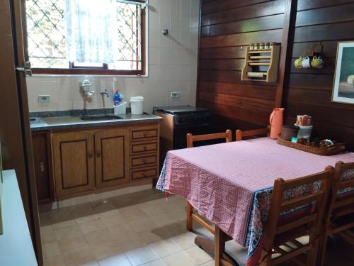 a kitchen with a table and a sink and a stove at Casa campos recanto in Campos do Jordão
