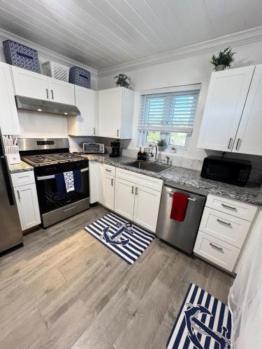 a kitchen with white cabinets and stainless steel appliances at All Decked Out, Exuma in Georgetown