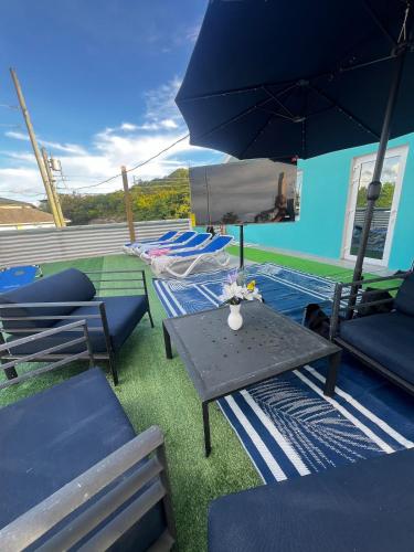 a patio with a table and chairs and an umbrella at All Decked Out, Exuma in Georgetown