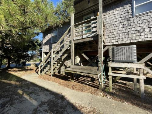 a wooden bench sitting in front of a house at CHASING SUNSETS cottage in Hatteras