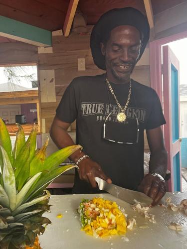 a man cutting a plate of food with a knife at All Decked Out, Exuma in Georgetown