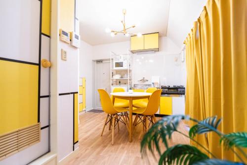 a kitchen and dining room with a table and yellow chairs at LEON RESORT HOTEL Max 9 people 3 min taxi Ikebukuro Station Tiffany Blue yellow Room 最大9名 池袋 in Tokyo