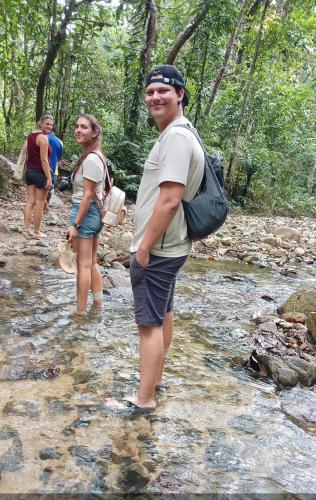 a group of people walking through a stream at SeaSide Rooms & Shuttles in Korotogo