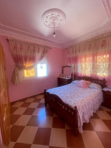 a bedroom with a bed with pink walls and curtains at VERSE 5 min de la playa in Riffiene
