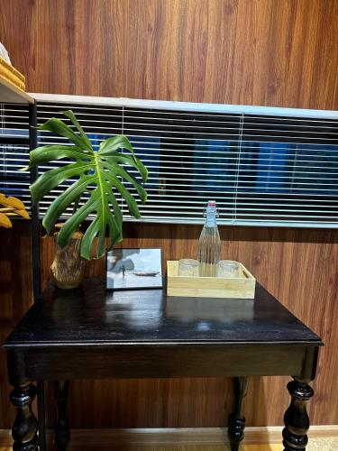 a black table with a plant and a window at B tree Retreat homestay in Thôn Dương Phẩm
