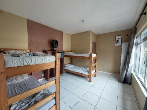 a room with three bunk beds and a window at Hostel Pantanal Em Florianópolis in Florianópolis