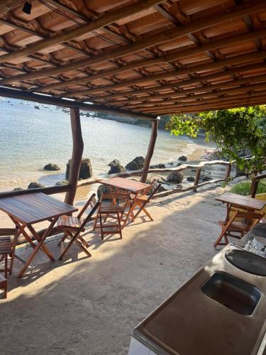 a group of picnic tables and chairs on the beach at Pousada Residence Vila das Flores in Morro de São Paulo