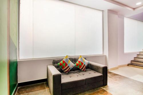 Hotel O PRAMOD PRIME HOMES في Surūrnagar: أريكة في غرفة مع وسادتين عليها
