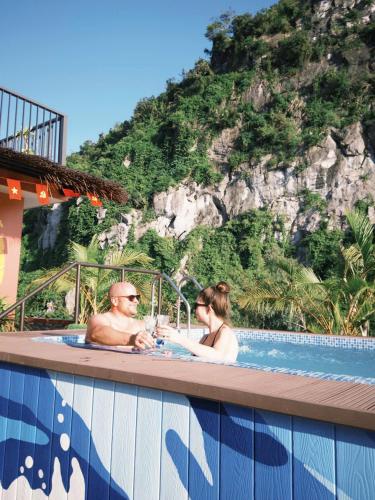 a man and woman in a swimming pool at a resort at Cat Ba Viet Hoa Hotel & Residence - Pool & Bar in Cat Ba