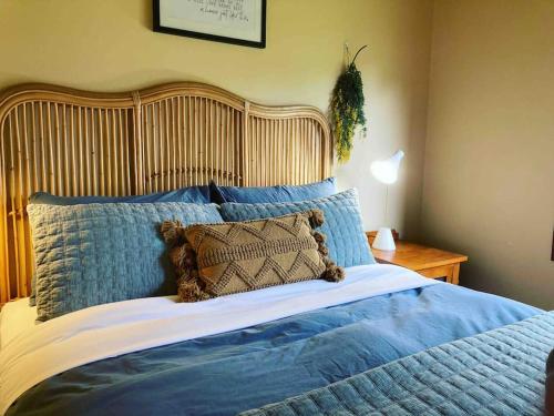 una camera da letto con un grande letto con lenzuola e cuscini blu di Red ceder cottage - Great ocean road - Port Campbell a Port Campbell