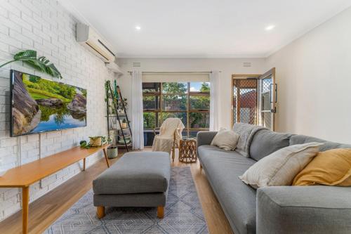 a living room with a couch and a table at Cozy Newtown 2 bedroom unit in Geelong
