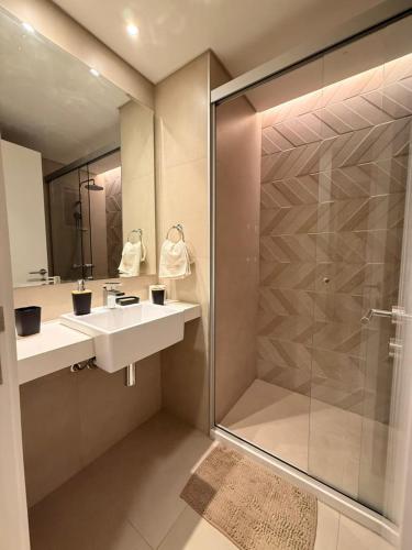 a bathroom with a sink and a glass shower at Houze 208 in Asuncion