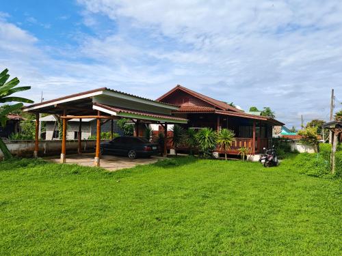 a house with a car parked in front of it at Passara Wooden House in Nan
