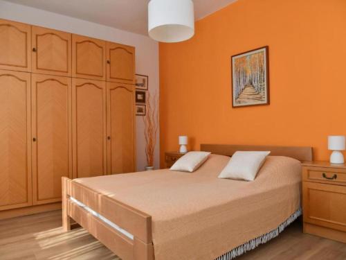 a bedroom with a bed with an orange wall at One Bedroom Apartment with Terrace & Garden View in Supetar