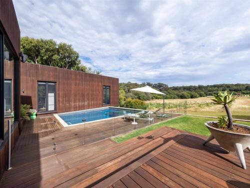 a backyard with a swimming pool and a wooden deck at Sophie's Vineyard - Sprawling Scenery with Pool in Yallingup Siding
