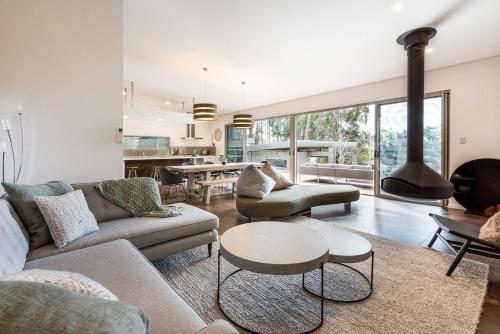 a living room with two couches and a fireplace at Sunrise Tranquillity - Luxe Retreat with Heated Spa in Yallingup Siding