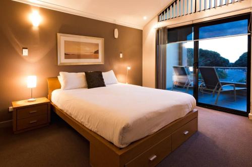 a bedroom with a large bed and a balcony at Surfside 8 - Spacious Retreat on Yallingup Beach in Yallingup