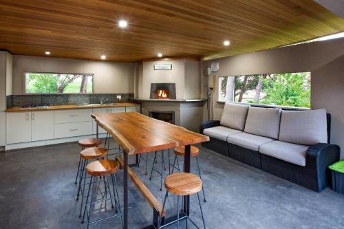 a kitchen and living room with a table and a couch at Sunrise Tranquillity - Luxe Retreat with Heated Spa in Yallingup Siding