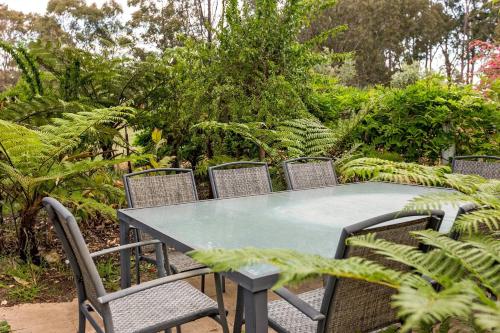 a table and chairs with a table and some plants at Sunrise Tranquillity - Luxe Retreat with Heated Spa in Yallingup Siding