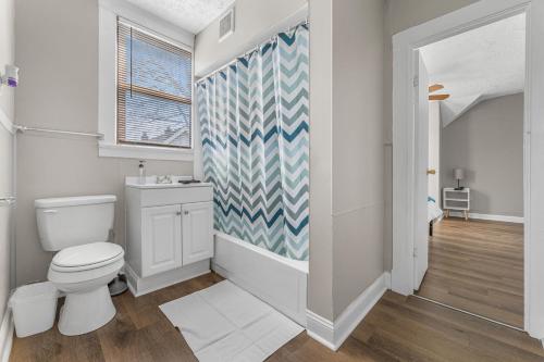 a bathroom with a white toilet and a blue patterned wall at Luxe Mattresses Pet Friendly Free Prkng WiFi in Cleveland