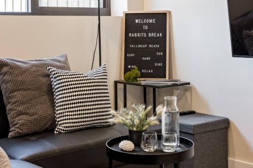 a living room with a couch and a table at Rabbits Break - Beachside Bliss Steps from Yallingup in Yallingup