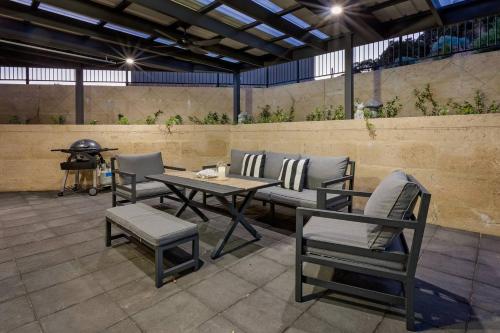 a patio with a table and chairs and a grill at Rabbits Break - Beachside Bliss Steps from Yallingup in Yallingup