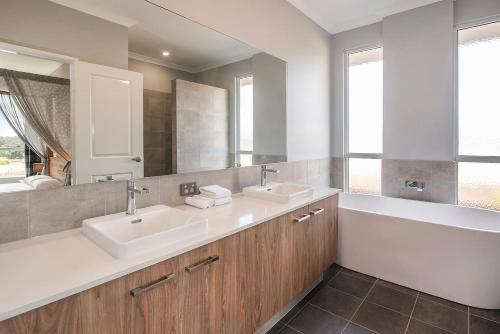 ein Badezimmer mit zwei Waschbecken und einem großen Spiegel in der Unterkunft Skibo House - A Family Retreat near Margaret River in Witchcliffe