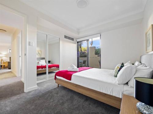 a bedroom with a large bed with a red blanket at Surfside 1 - An Unforgettable Yallingup Experience in Yallingup