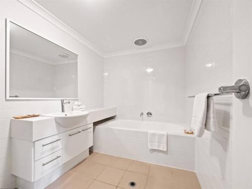 a white bathroom with a sink and a bath tub at Surfside 1 - An Unforgettable Yallingup Experience in Yallingup