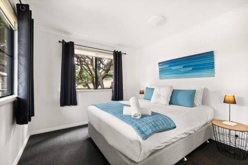 a bedroom with a large bed and a window at Surfers Paradise - Oceanview Garden Beach House in Yallingup