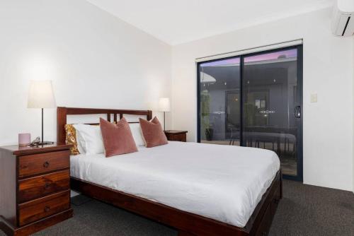 a bedroom with a large bed and a glass door at The Enclave - A Family Alfresco Retreat in Dunsborough