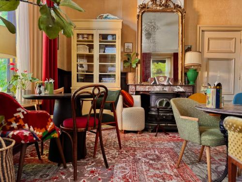 a living room with a table and chairs and a fireplace at Villa Abbekerk - Bed & Breakfast in Abbekerk