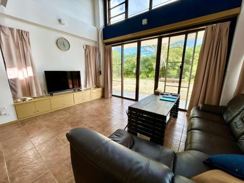 una sala de estar con un sofá y una mesa en 川平湾から車で10分シアター付きシークレットシーサー, en Ishigaki Island